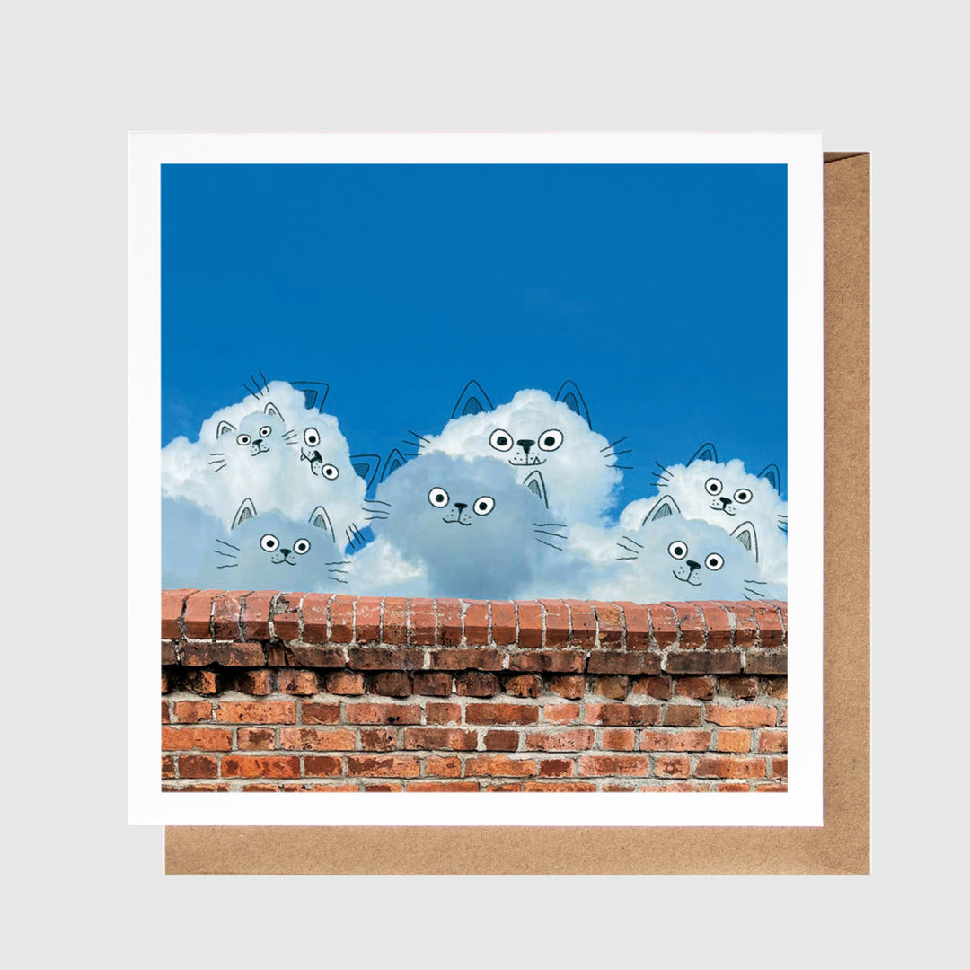 Card with cartoon cats on a blue sky background and brick wall at the bottom